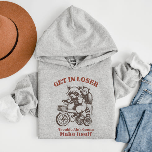 Fuel your wild side with our bold and hilarious hoodie featuring a mischievous raccoon and possum duo cruising on a bike.